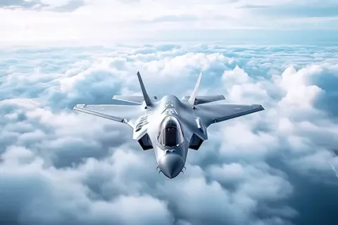 A futuristic stealth fighter jet cruises above the clouds.