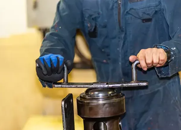 A worker lapping the seat of an engine starting valve with focus and precision